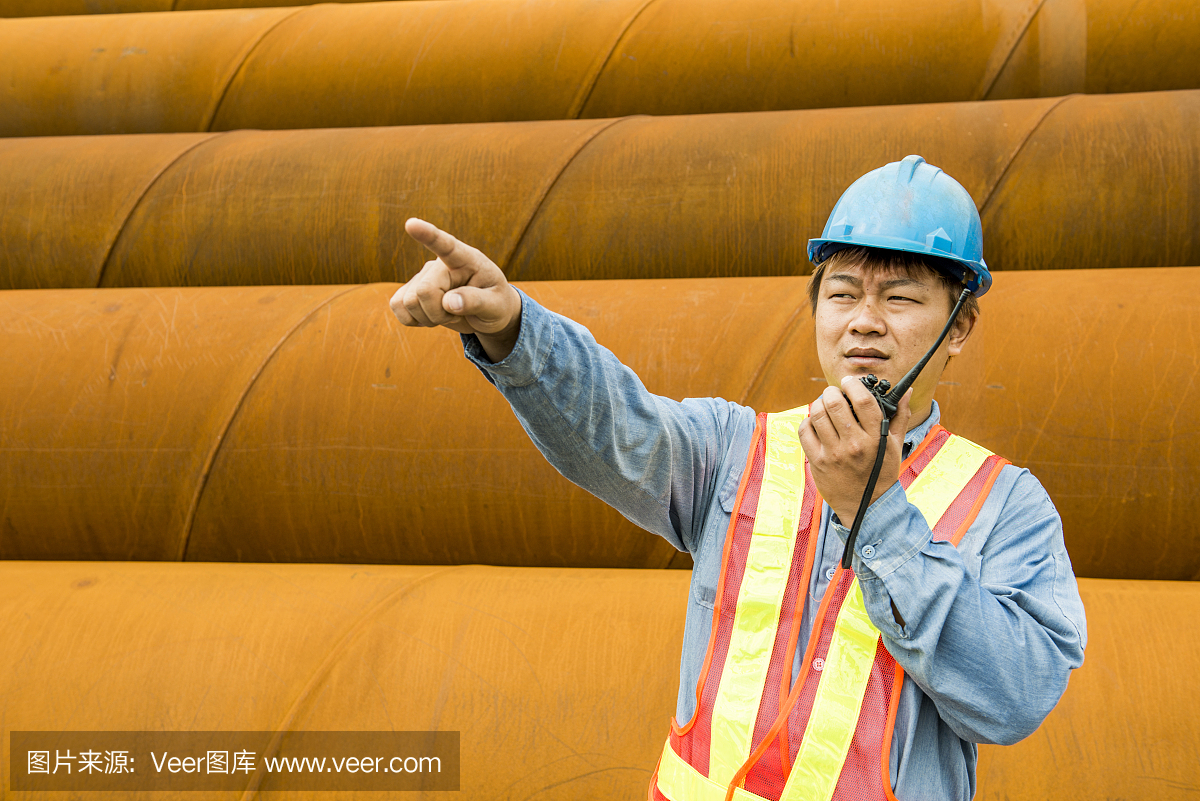 建筑工人在起重機(jī)的背景下檢查現(xiàn)場(chǎng)